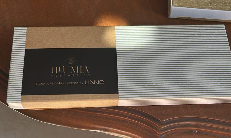 Incense packaging with 'UNNE' branding on a wooden surface