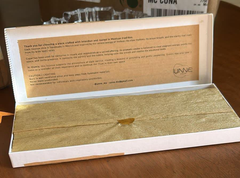Unve brand packaging with gold product on a wooden surface