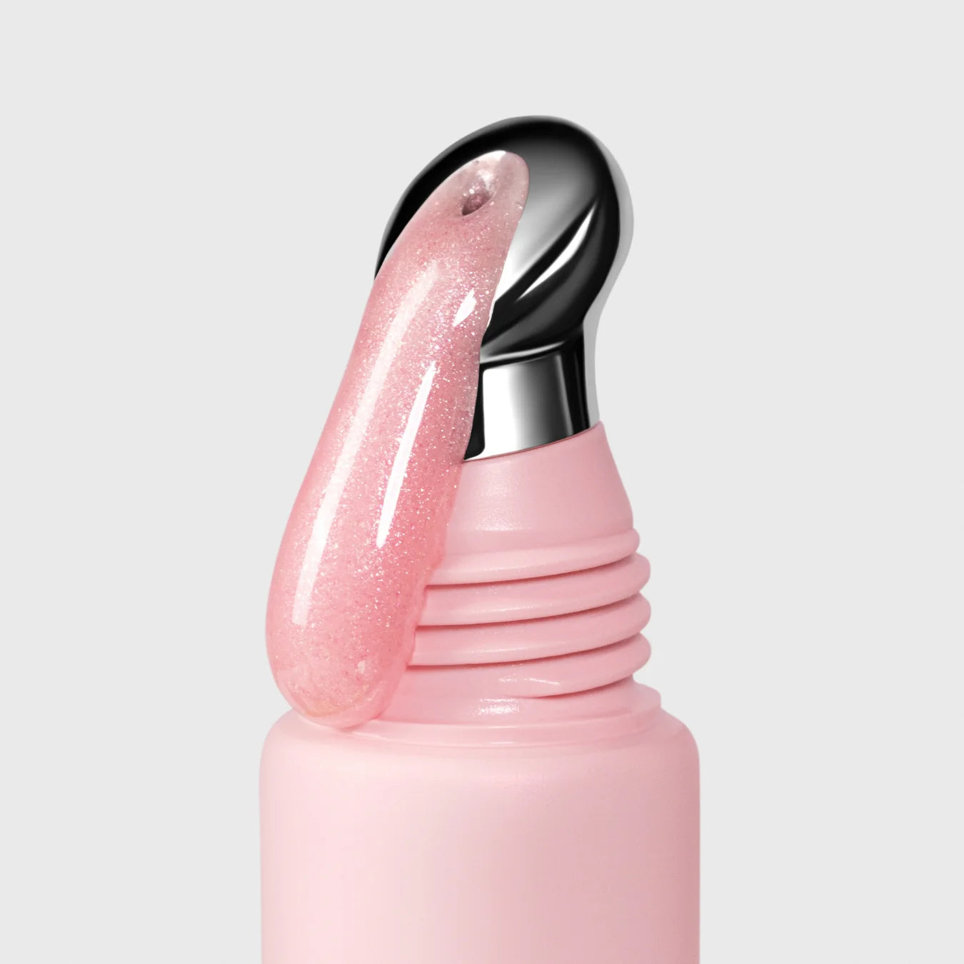Pink lip gloss with a silver cap on a light gray background