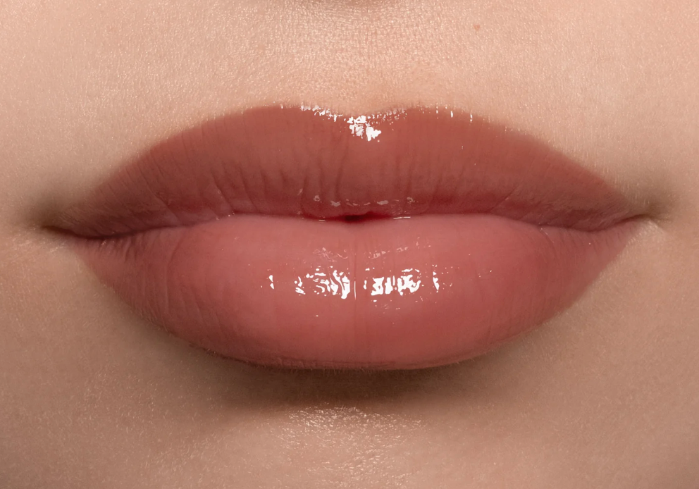 Close-up of glossy lips with a neutral background
