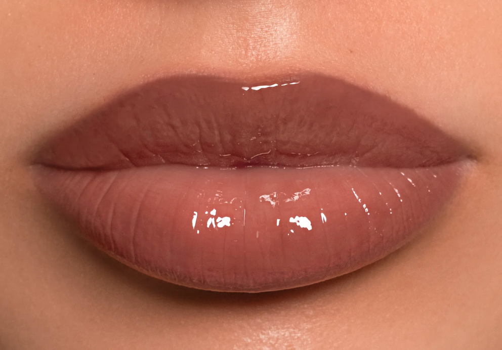 Close-up of glossy pink lips with a neutral background
