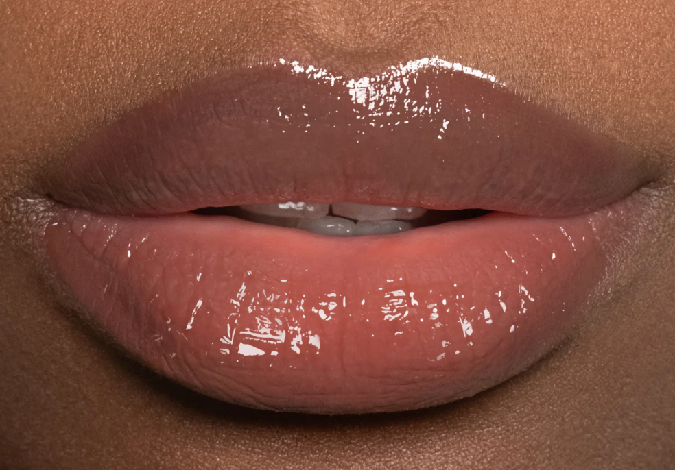 Close-up of glossy lips with a neutral background